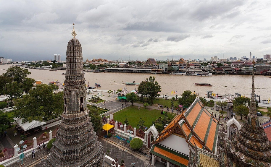 A river with boats, a temple with a spire, and a cityscape in the background. 3