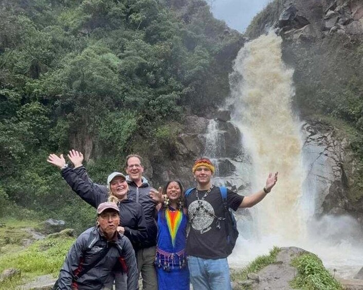 A waterfall with people standing in front of it. 5
