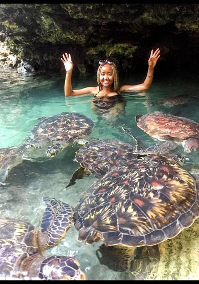 A person swimming with sea turtles in clear water. 3