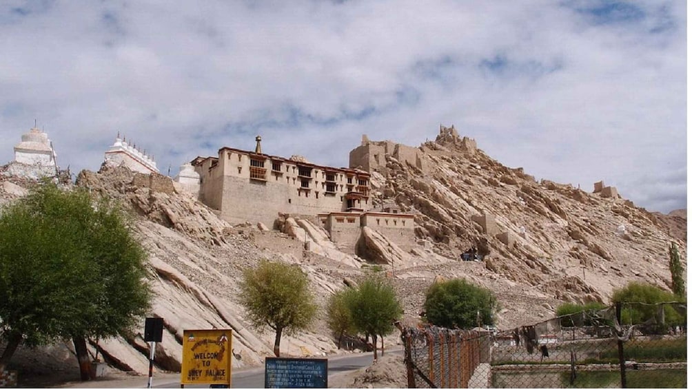 A historic monastery complex on a hillside with a clear sky. 3