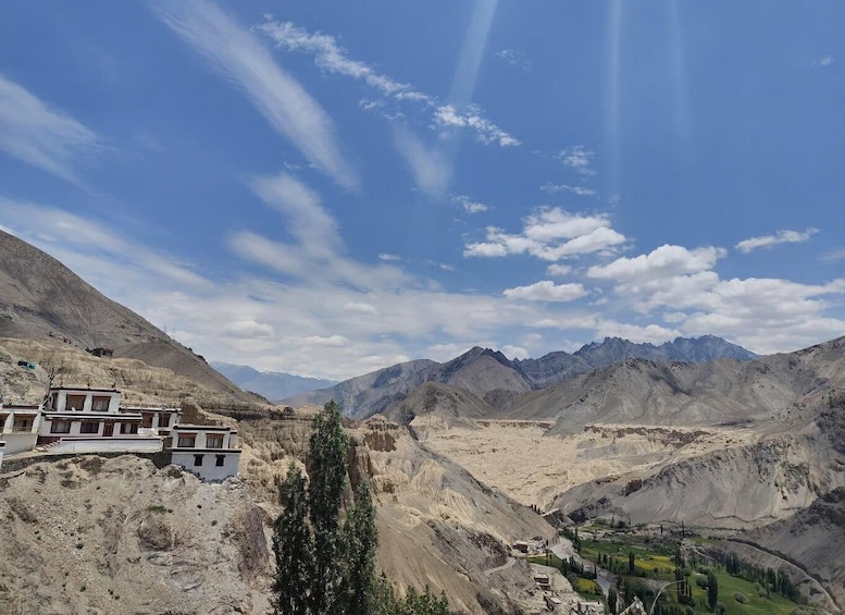 A mountainous landscape with a clear sky, a valley, and a building with traditional architecture. 5