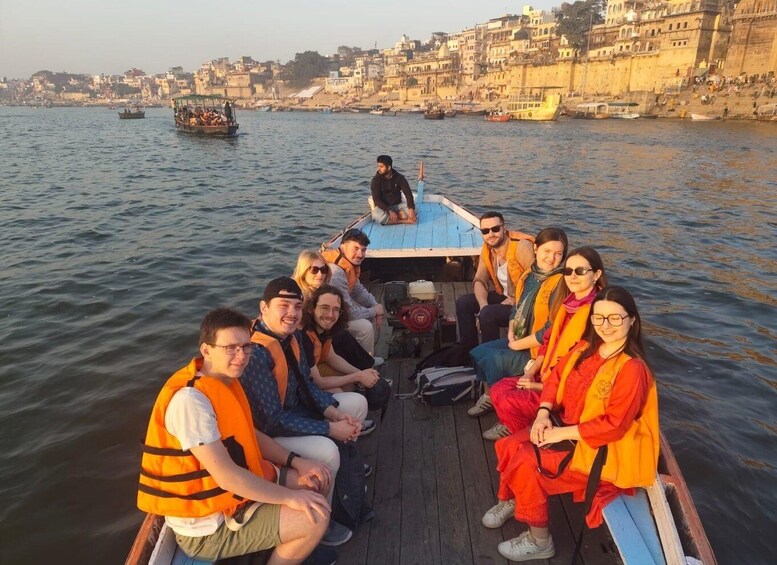 Un grupo de personas en un bote en un río, con edificios al fondo. 5
