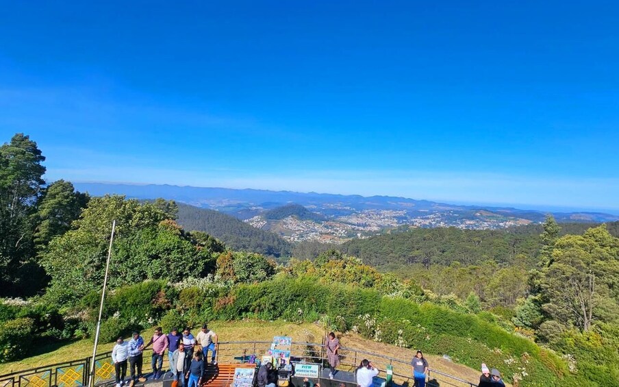 A group of people on a hill overlooking a valley with a clear blue sky. 3