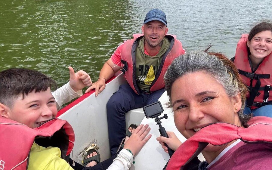 A group of people on a boat with life jackets, taking a selfie. 1