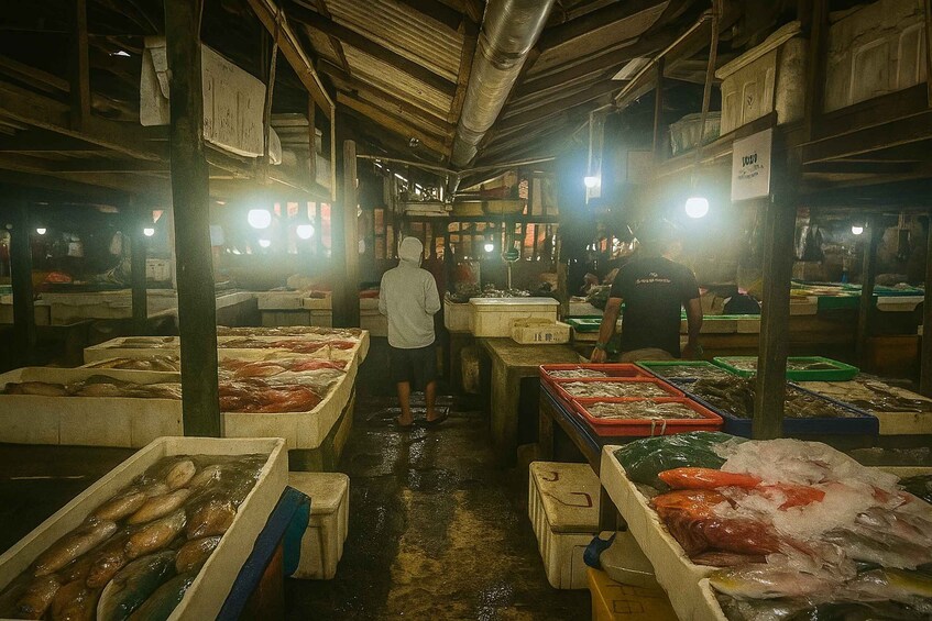 A bustling indoor fish market with various seafood displayed in ice-filled containers. 5