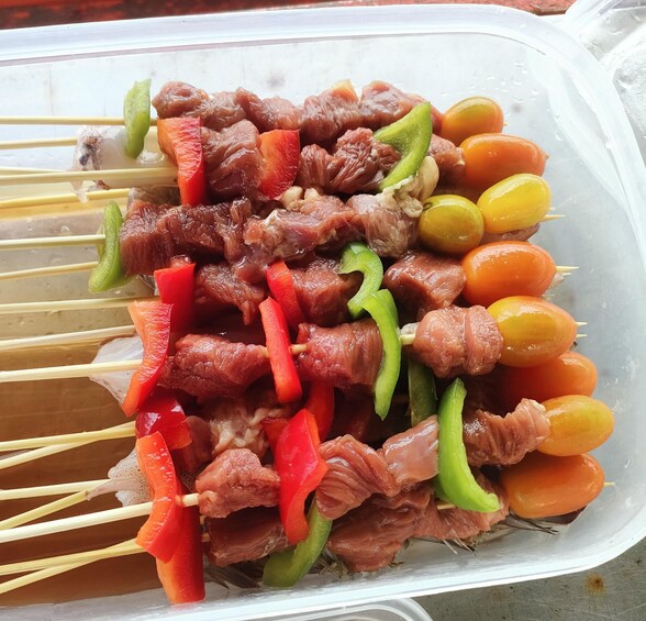 Skewered meat and vegetables in a plastic container. 5