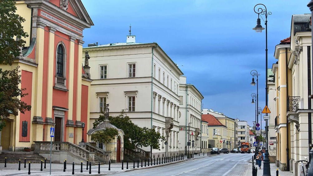 A street lined with historic buildings, a pedestrian crossing, and a clear blue sky. 4