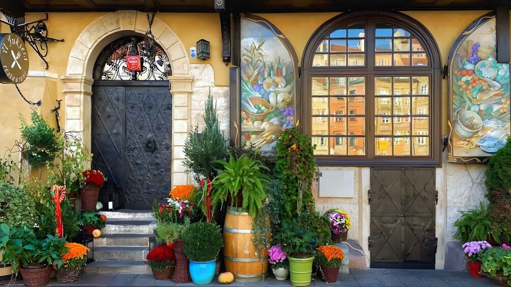A building with a black door, a sign reading 'Yukien Restaurant,' and a mural of fruits and vegetables. 5