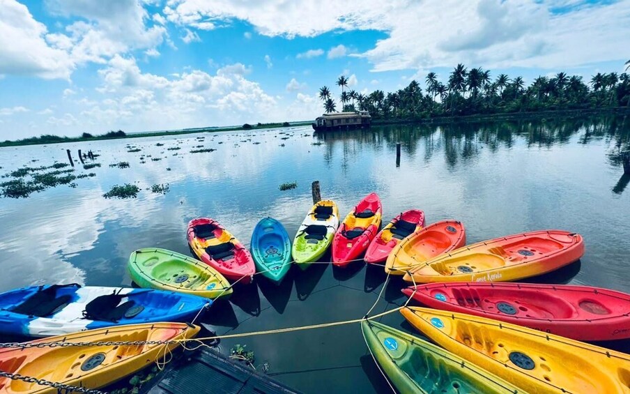 A calm lake with kayaks tied up in the foreground and a houseboat in the background. 5
