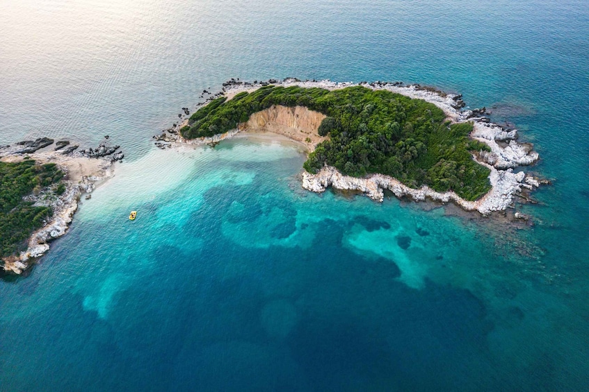 An aerial view of a small island with clear turquoise waters and lush greenery. 5