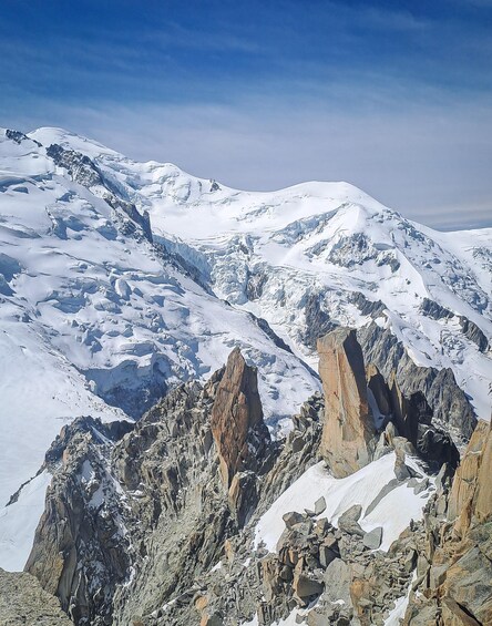 A snow-covered mountain range with rocky outcrops and glaciers. 4
