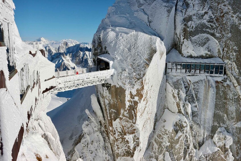 A snow-covered mountain with a bridge and a glass building. 1