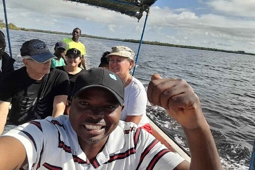 A group of people on a boat with a body of water and a distant shoreline in the background. 3