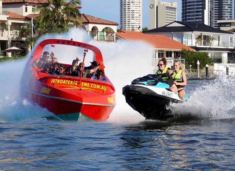 A red jet ski and a black jet ski on water with buildings in the background. 3