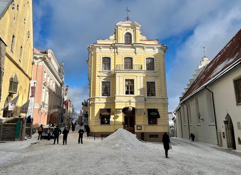 A snow-covered street with historic buildings, including a prominent yellow building with a dome. 5