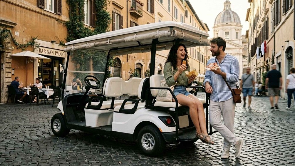 A couple on a golf cart in a cobblestone street with buildings and a bar in the background. 1