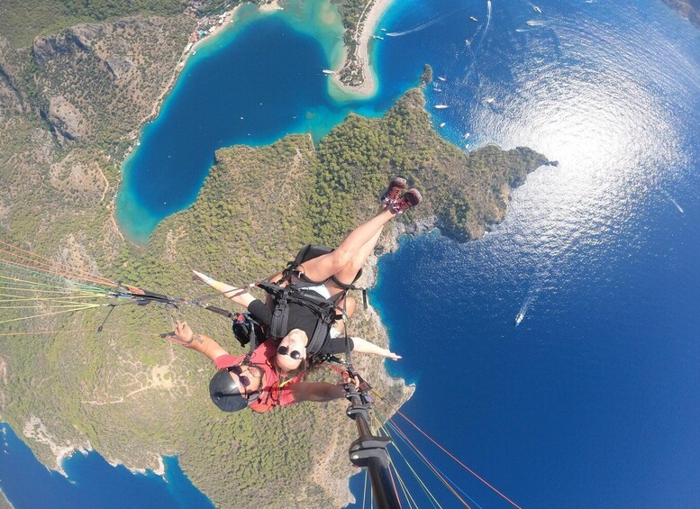 A person skydiving with a parachute over a coastal landscape. 1