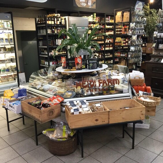 A cheese display in a grocery store with various cheeses and related products. 5