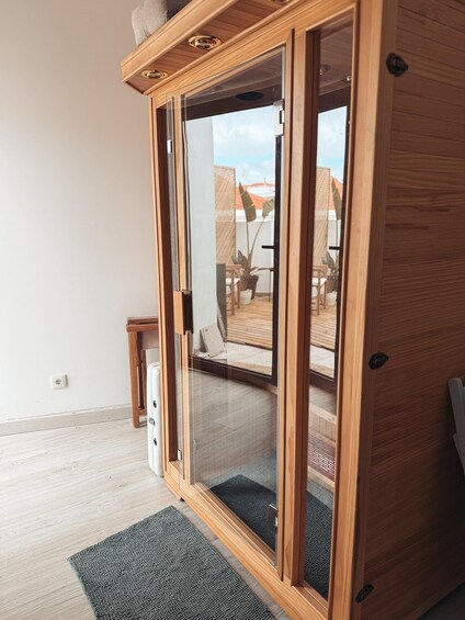 A wooden sliding door leading to an outdoor patio area with a view of a house and a clear sky. 3