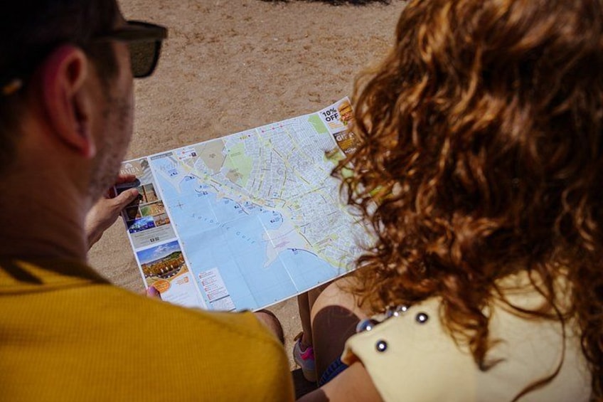 A person holding a map with a coastal cityscape. 2