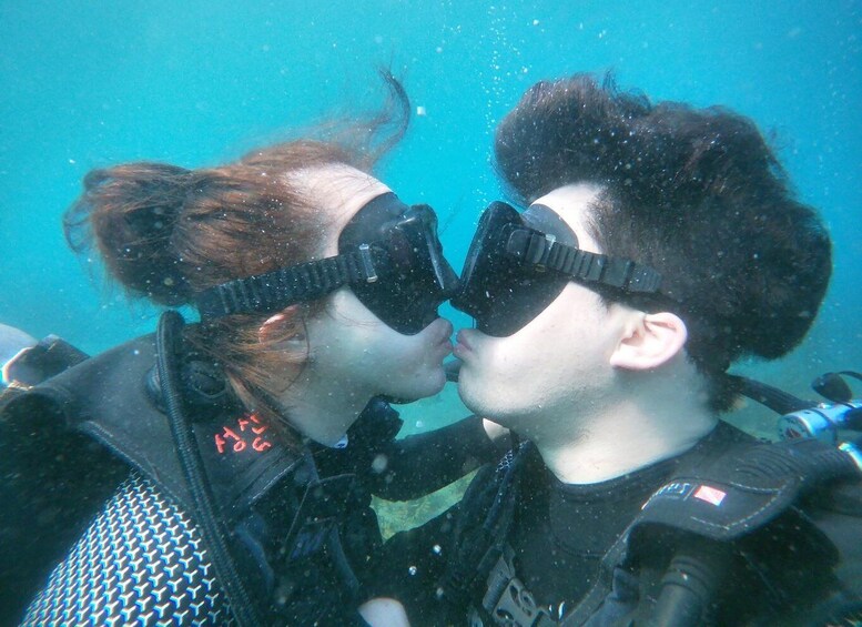Two people underwater wearing scuba gear, with bubbles around them. 4