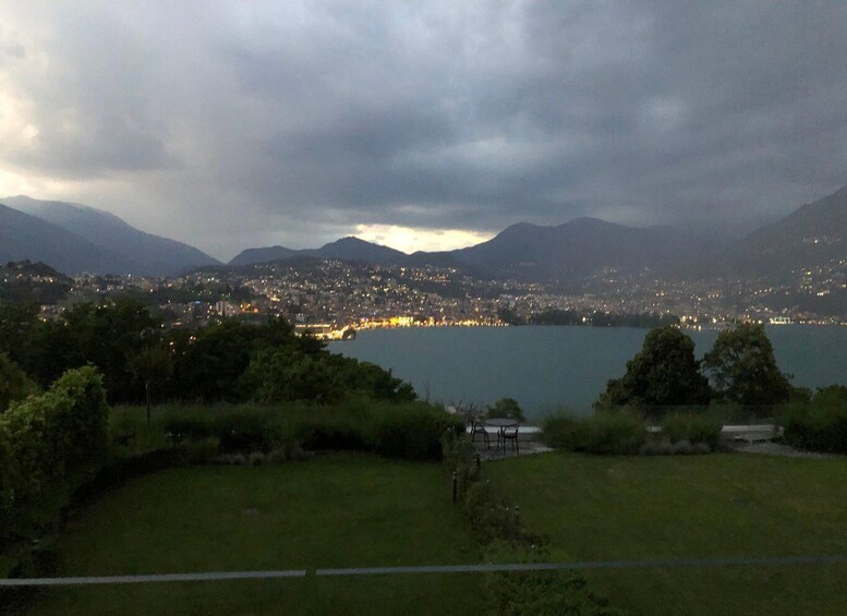 A coastal city at dusk with mountains in the background and a body of water in the foreground. 5