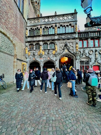 A historic building with intricate architecture, a crowd of people, and cobblestone pavement. 5