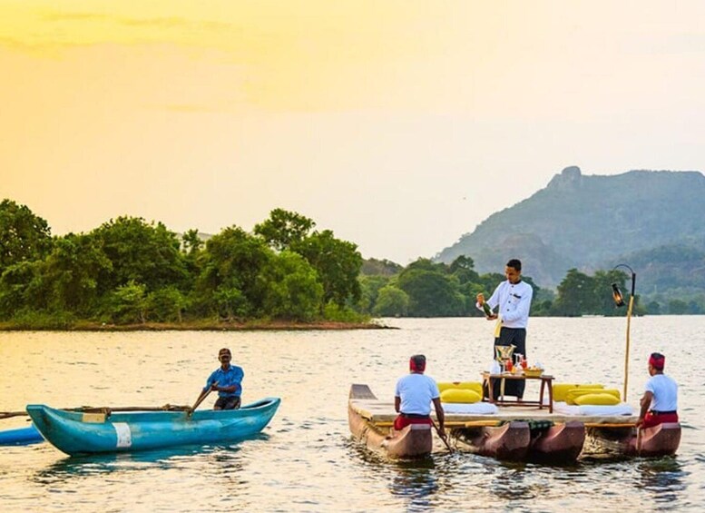A group of people on a boat, a man standing on a platform, and a mountainous landscape in the background. 4