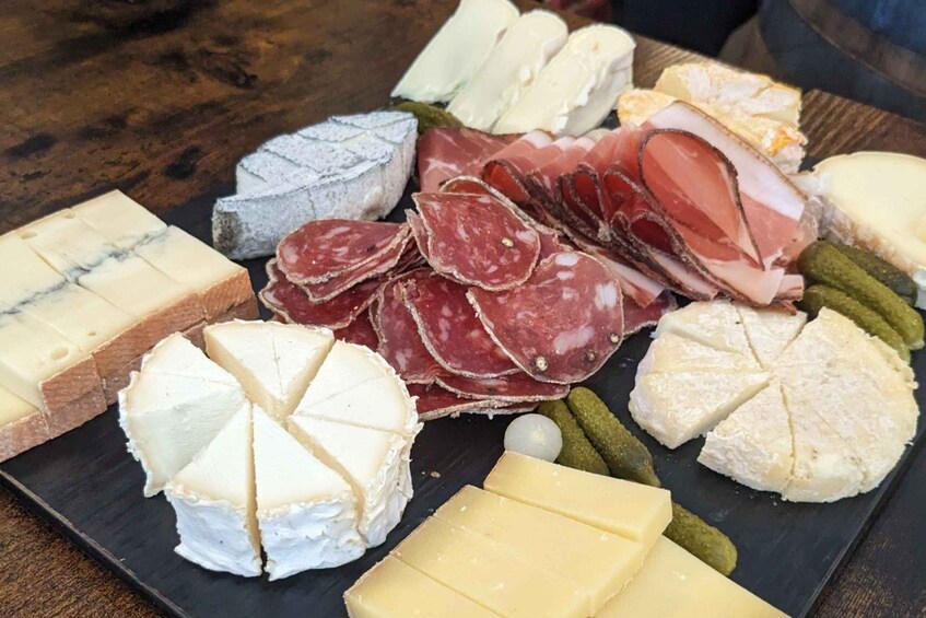 A charcuterie board with various cheeses, cured meats, and pickles. 4