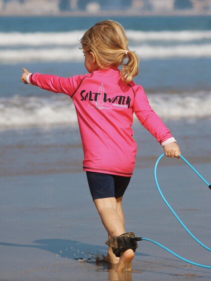 A child playing with a hula hoop on the beach. 5