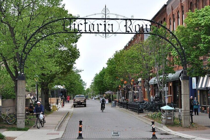 A street with a sign reading 'Victoria Row,' lined with trees and shops. 4