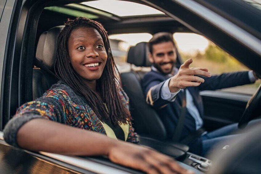 A person in a car, wearing a colorful sweater, with a hand extended out of the window. 3