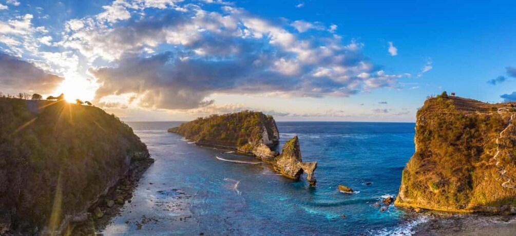 A coastal landscape with cliffs, a clear sky, and the sun setting or rising over the water. 3