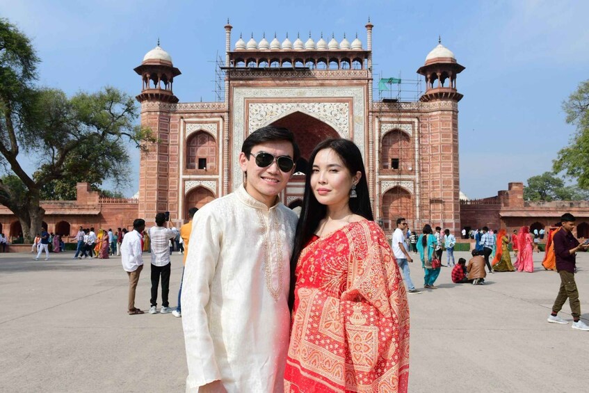 A historic building with intricate architecture, a large open courtyard, and people in traditional attire. 3