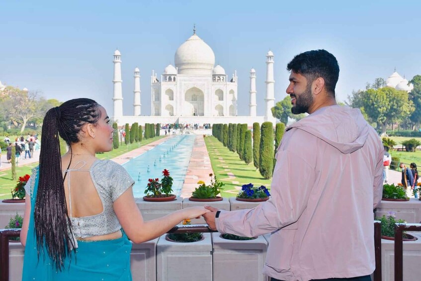 A couple holding hands in front of the Taj Mahal. 2