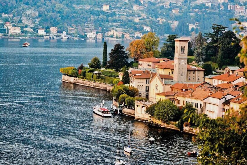 A riverside town with a prominent tower, boats, and lush greenery. 3