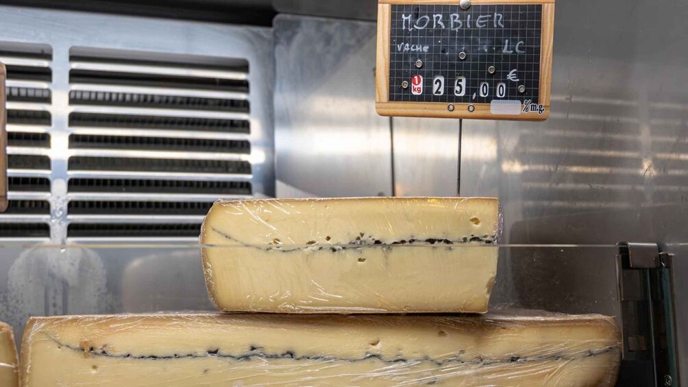 A cheese display with a price tag and a scale. 3