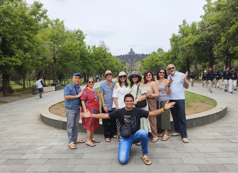 A group of people posing in a park with a large building in the background. 5