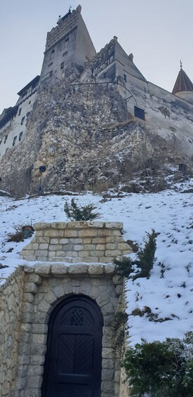 A historic stone building with a prominent tower and a snow-covered landscape. 3