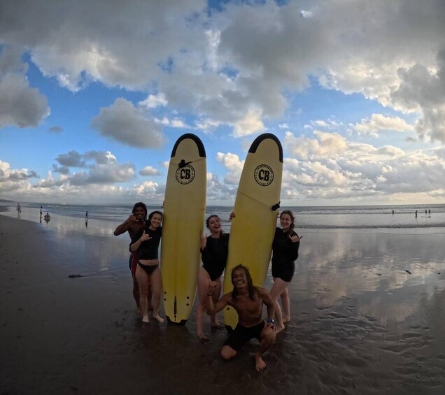 A group of people on a beach holding surfboards. 5