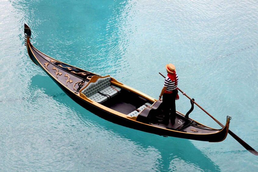 A gondola with a single passenger on a calm water body. 4