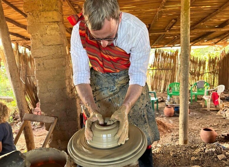 A person shaping a clay pot on a wheel. 4