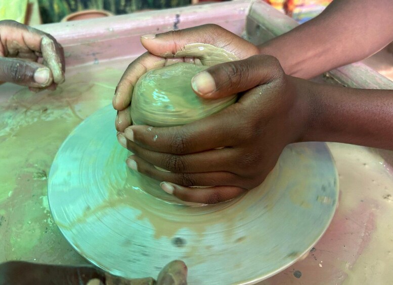 Hands shaping a clay pot on a spinning wheel. 5