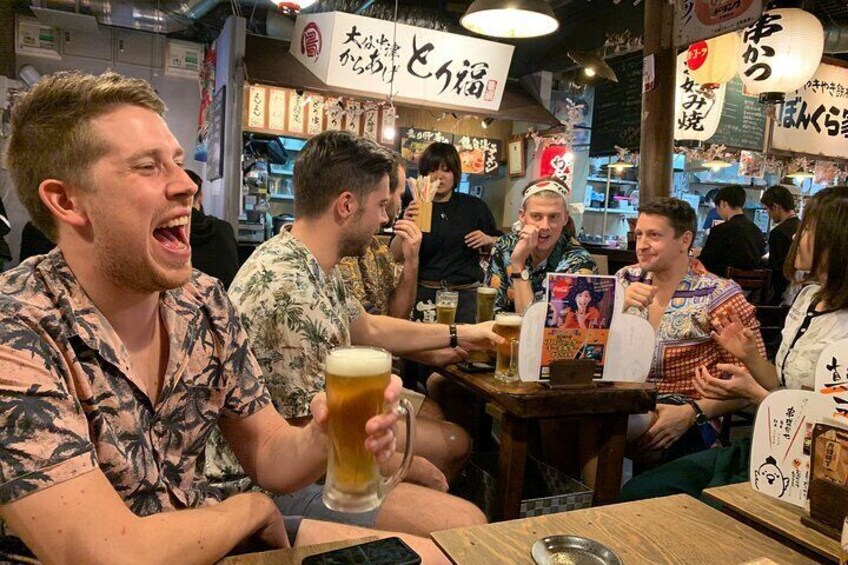 People sitting at tables in a restaurant with Japanese signage. 3
