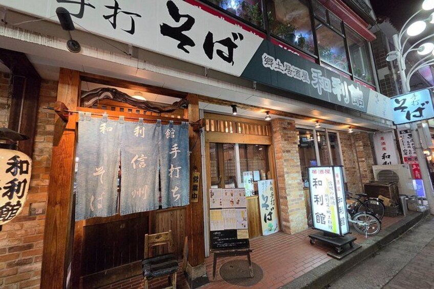 A restaurant with a signboard, wooden shutters, and a bicycle parked outside. 5