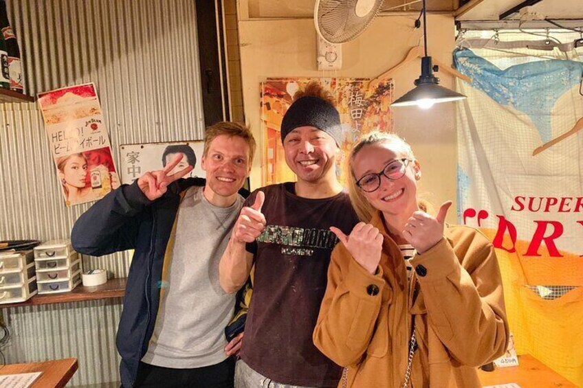 Three people posing in a room with posters and a curtain. 4