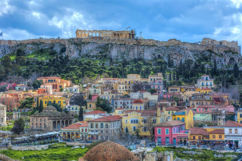 A coastal cityscape with colorful buildings, a prominent ancient ruin on a cliff, and a dome structure in the foreground. 1