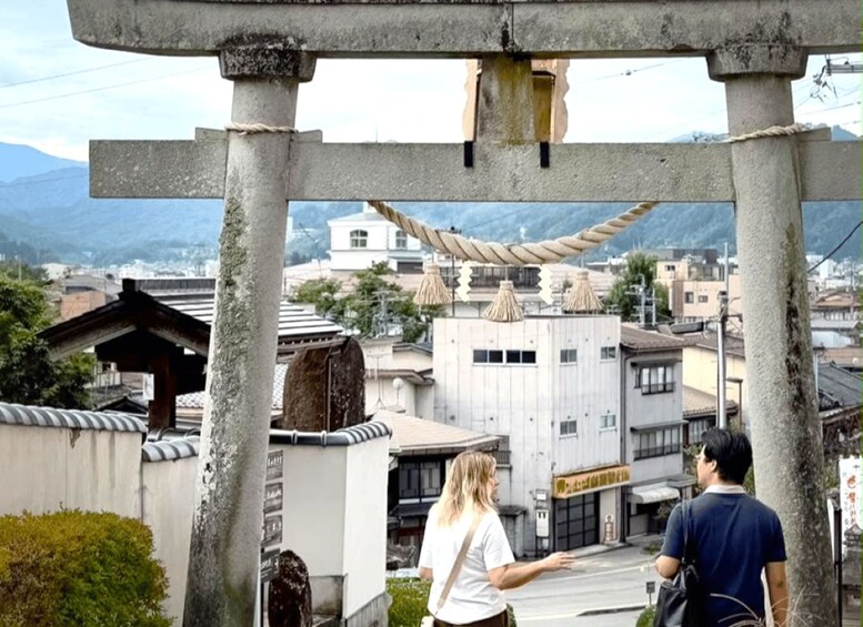A traditional Japanese torii gate with a view of a cityscape in the background. 2
