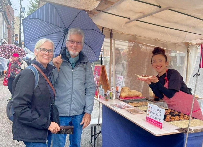 A street vendor stall with food items and a sign listing prices in Japanese yen. 5