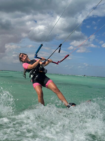 A person windsurfing on turquoise water with a clear sky. 4